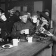 Black and white photo of navy sailors lining up to receive coffee and doughnuts